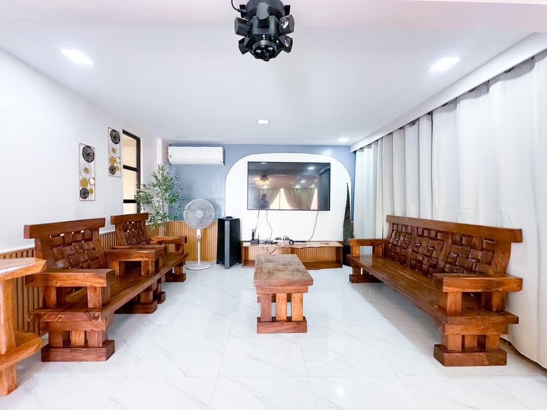 Bright TV lounge with wooden seating at The Resthouse
